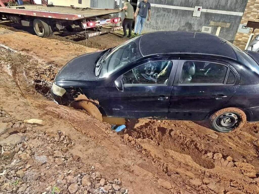 Cratera que atolou caminhão de lixo agora deixa Voyage preso em rua